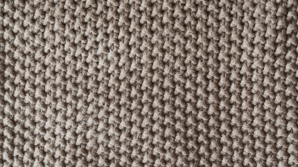 Gros plan sur un tricot en point mousse beige